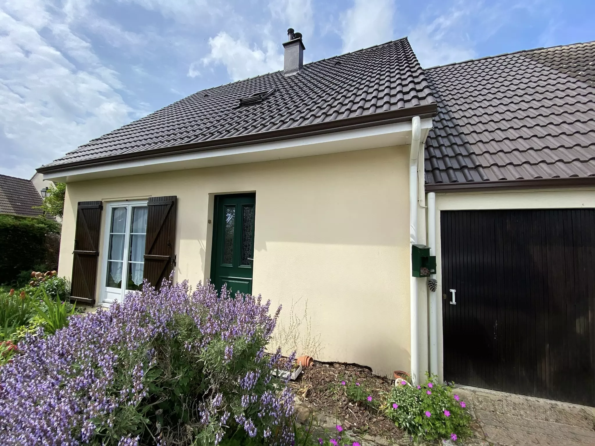 Maison vu de face avec vision sur la toiture en résine hydrofuge colorée ainsi qu'une très belle façade.