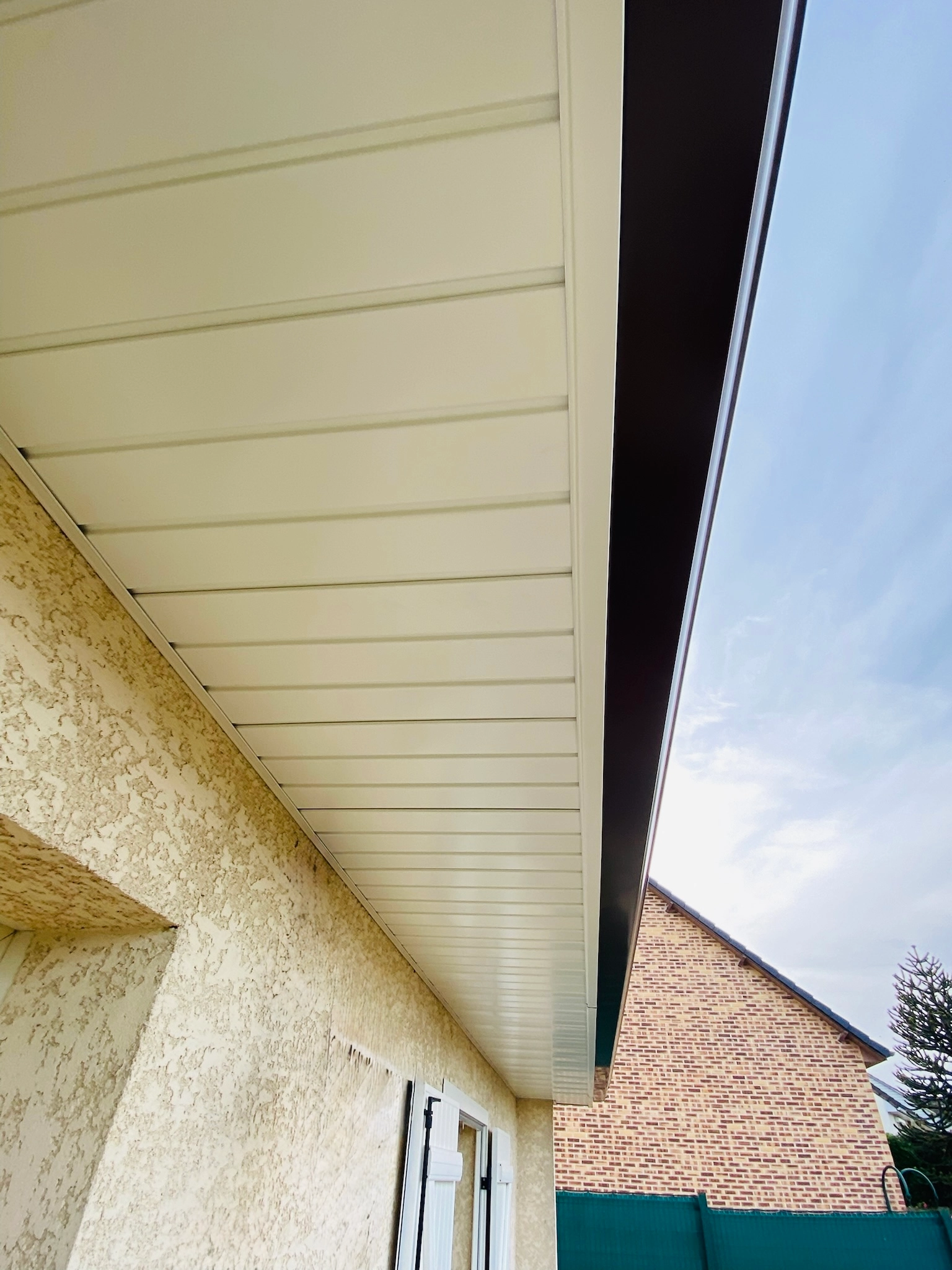 Vu d'une devanture de maison de profil pour insister sur la présence d'un cache moineau très bien installé