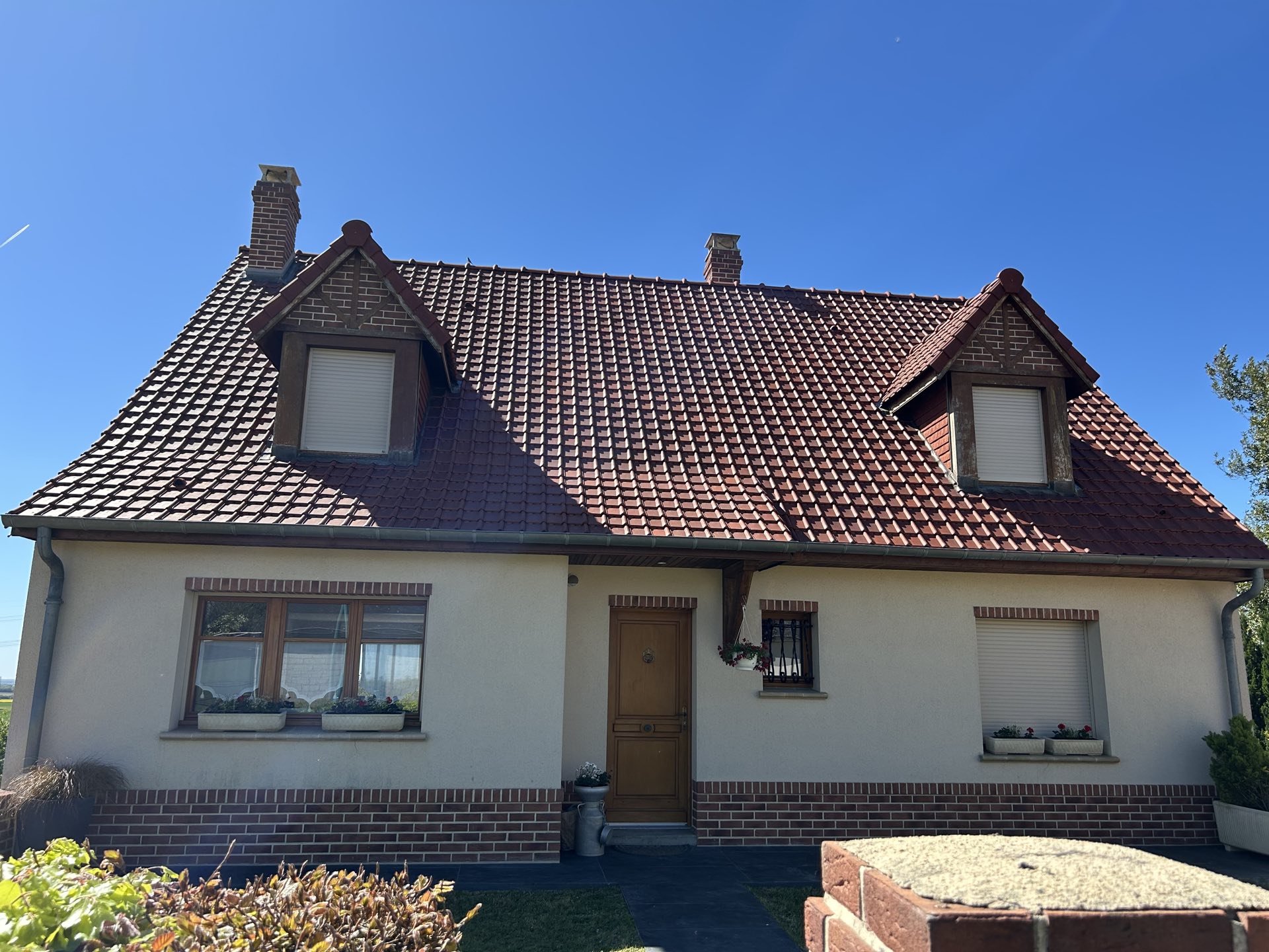 Toiture en tuiles rénovée et entretenue sur une maison près d'Amiens